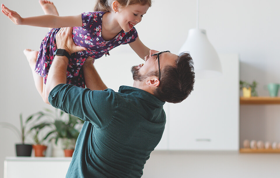 dad holding daughter in the air