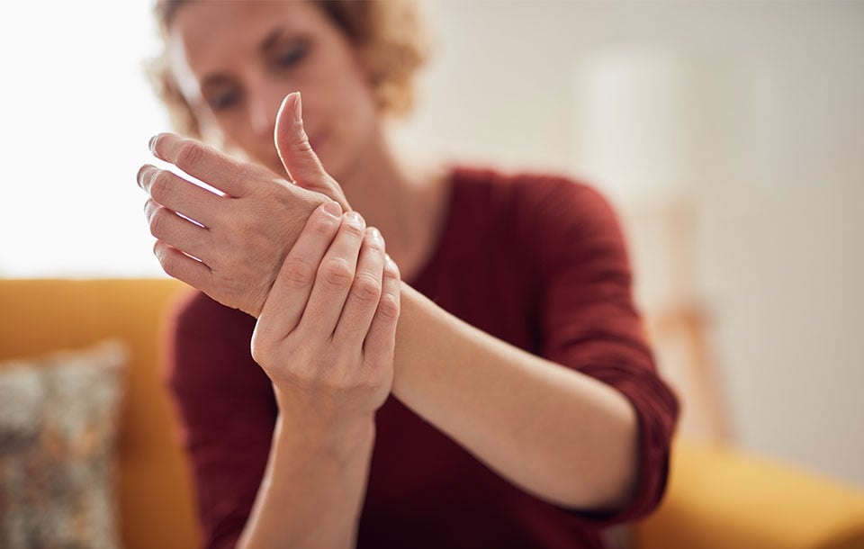 woman gripping hand in pain